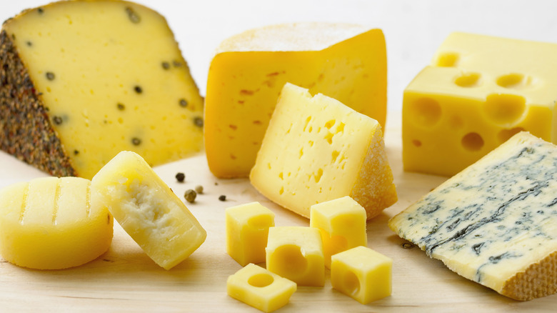 different cheeses on wooden board