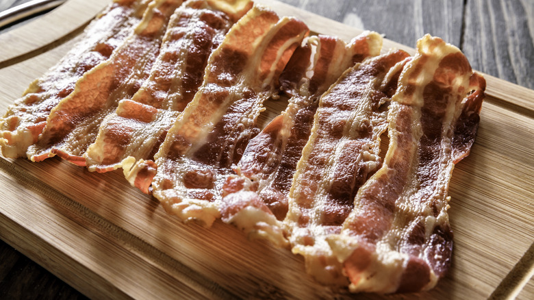 cooked bacon on cutting board