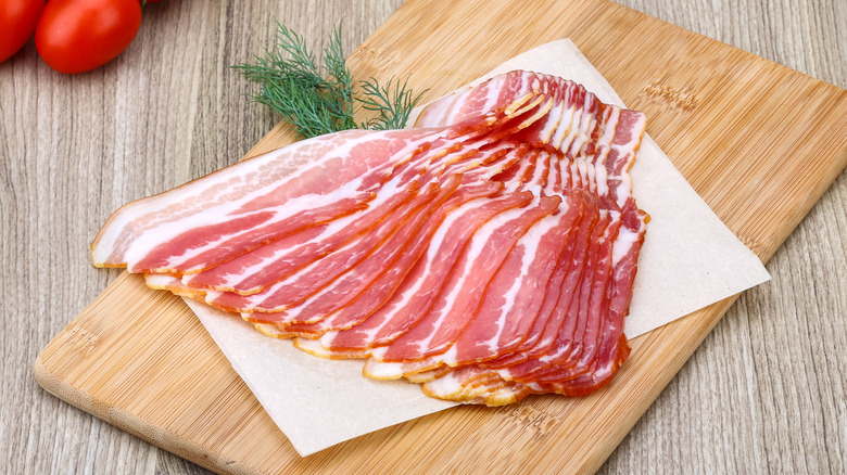 Raw sliced bacon with dill