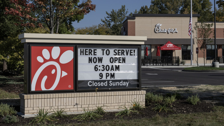 Chick-fil-A restaurant sign outside Chick-fil-A restaurant, displaying its opening times