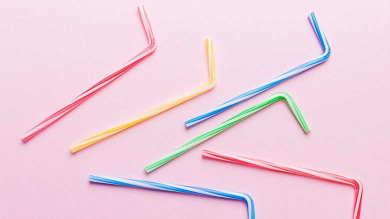 Colorful drinking straws on pink background