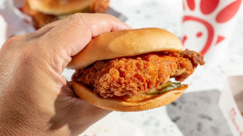 Hand holding a Chick-fil-A sandwich