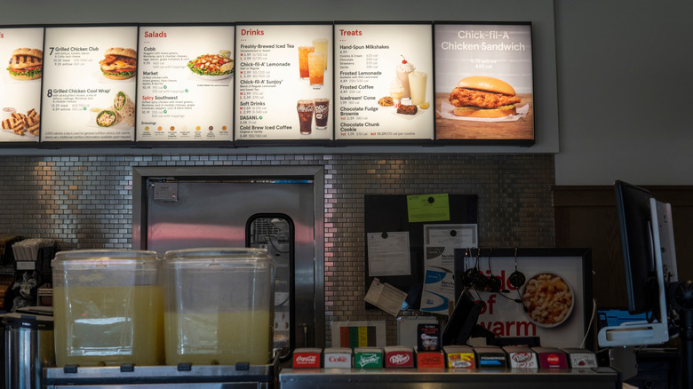 Chick-fil-A store interior, with menu lit up behind the counter