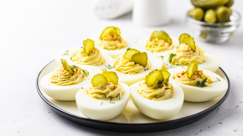 plate of deviled eggs with pickles