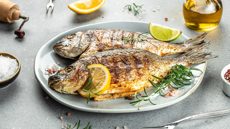 Plate of grilled whole fish with lemon