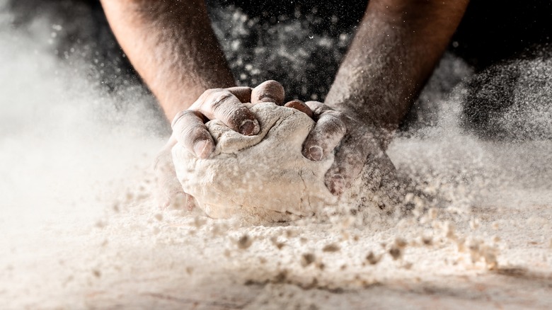 person kneading dough