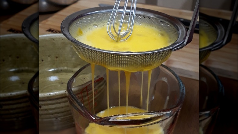 Straining yellow egg mixture