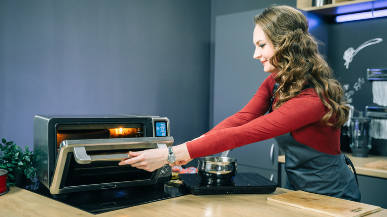 Woman opening toaster oven