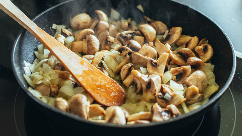 Veggies being sautéd in pan