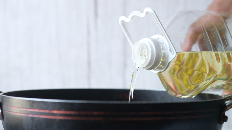 vegetable oil pouring into pot