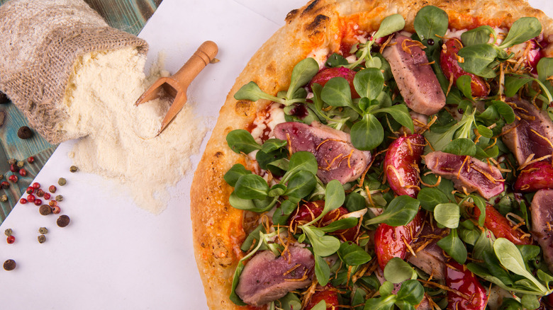 Duck meat on pizza with greens