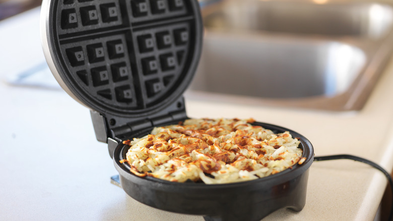 Potatoes cooking in waffle iron