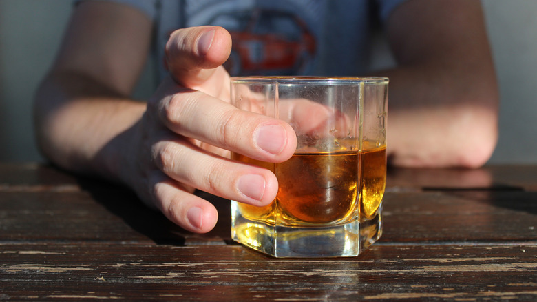 hand holding whiskey glass