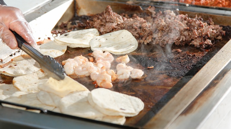 shrimp cooking on flat-top griddle