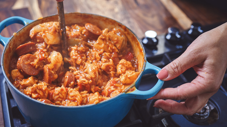 person stirring pot of jambalaya