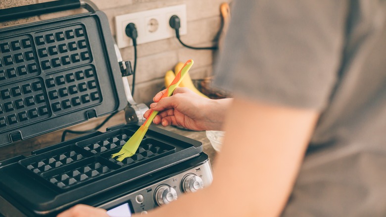 brushing oil on waffle maker