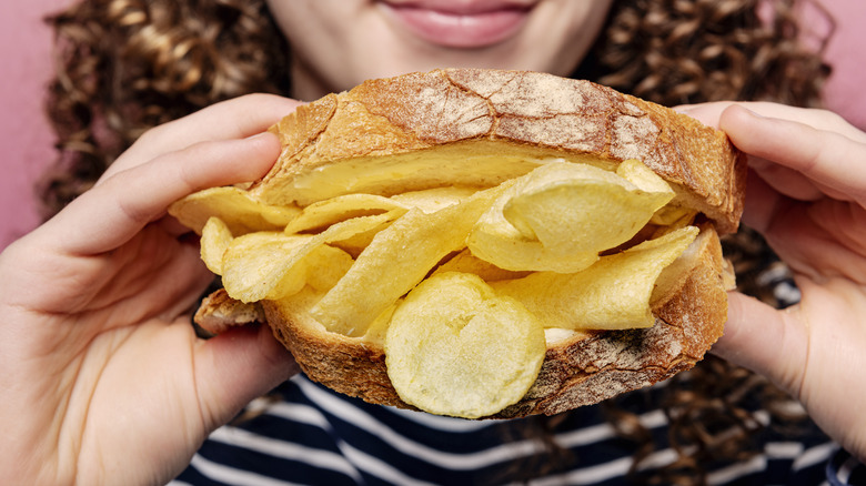 Woman holding potato chip sandwich