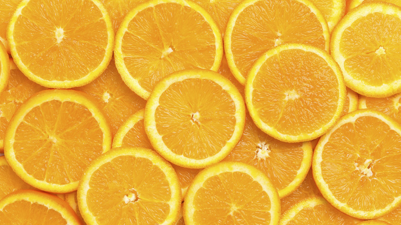 Fresh orange fruit slices on orange background