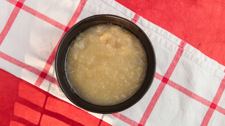 Black bowl of applesauce on tartan tablecloth