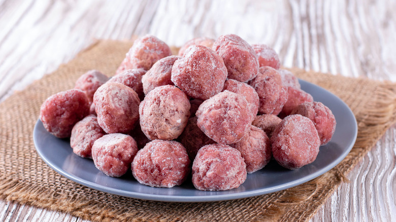 Frozen meatballs on a plate placed on a wooden table