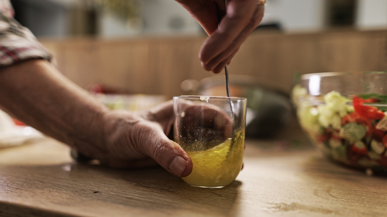 Hands mixing salad dressing