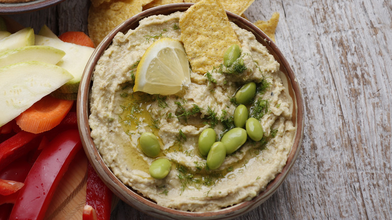 bowl of hummus garnished with edamame