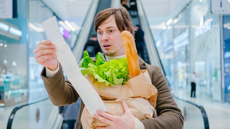 Man holding a grocery receipt