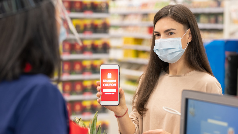 Woman showing a coupon at checkout