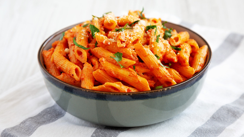 Bowl of penne alla vodka topped with herbs and Parmesan