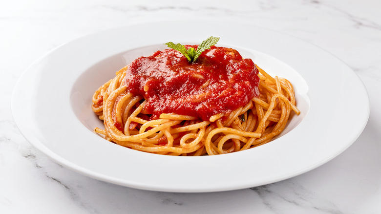 Bowl of spaghetti topped with tomato sauce