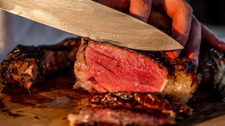 steak being sliced on board