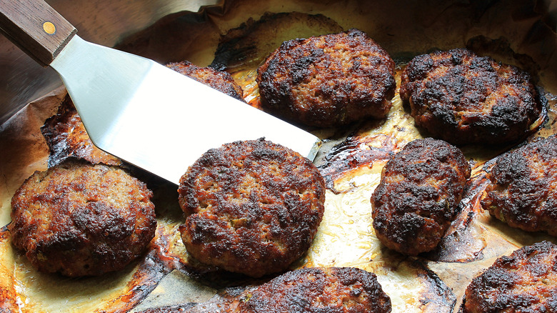 burnt burgers on a spatula