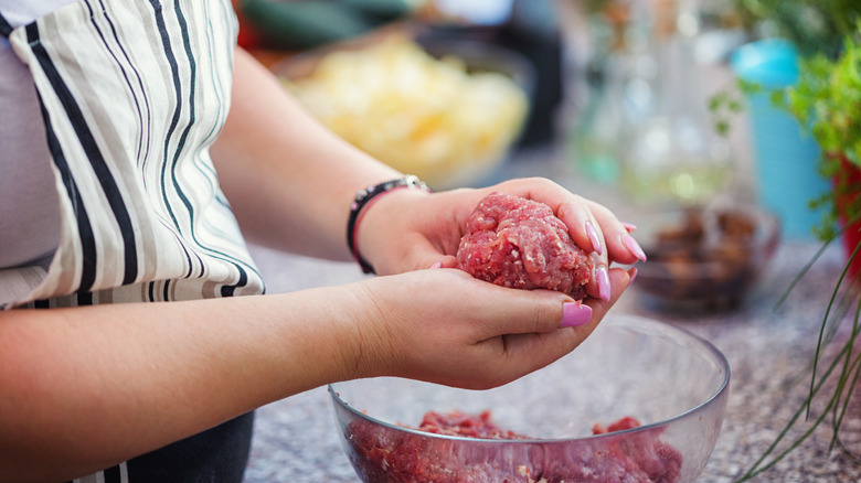 person making burgers in bowl