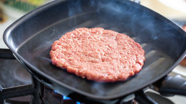 burger patty cooking in skillet