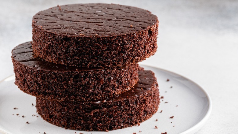 Three unfrosted layers of chocolate cake