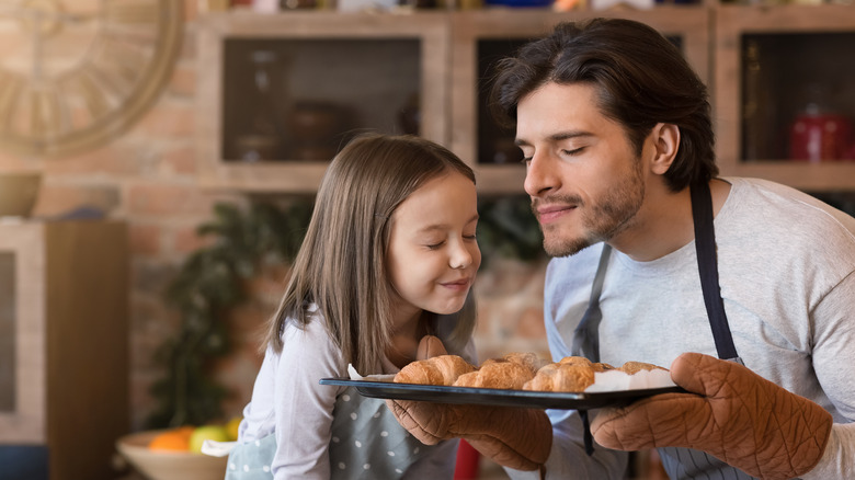 Father and daughter smelling pastries