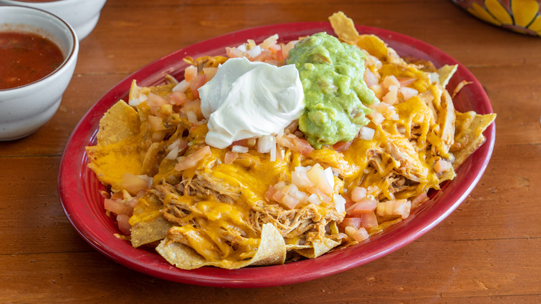 shredded chicken nachos with sour cream and guacamole