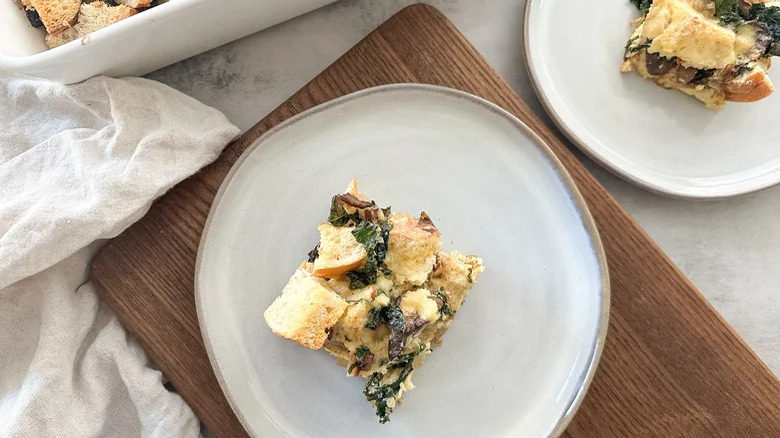 Top-down view of kale and mushroom strata on a white plate