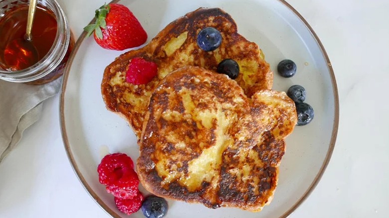 Top-down view of French toast topped with blueberries and strawberries