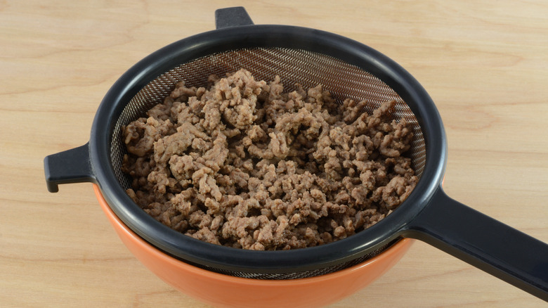 ground beef being strained