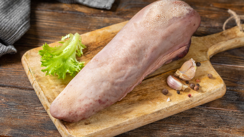 Raw beef tongue wooden board