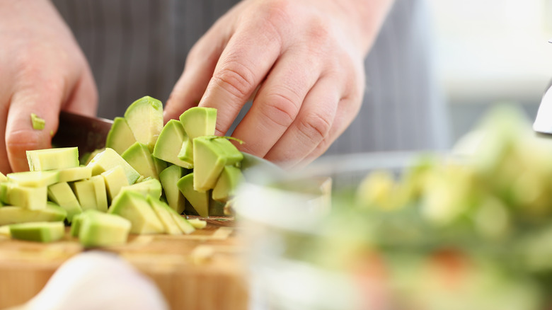 Person chopping avocado