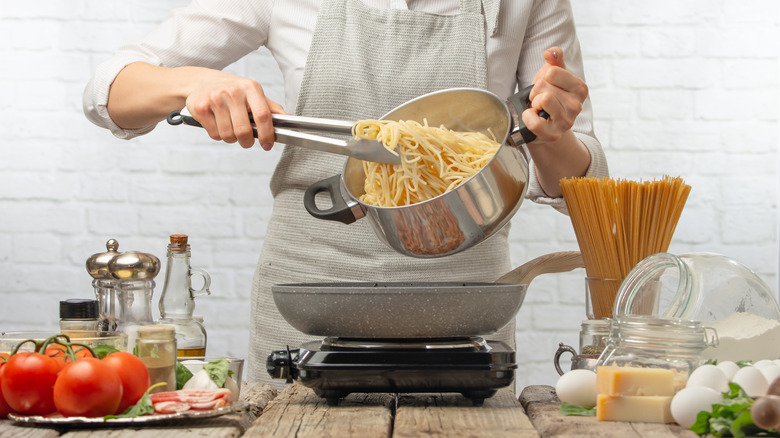 Chef putting pasta into pan