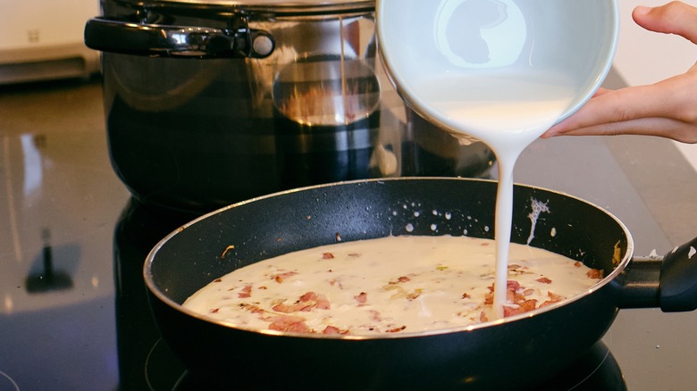 Adding cream to carbonara sauce