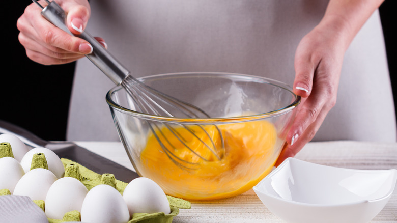 Woman whisking eggs in bowl