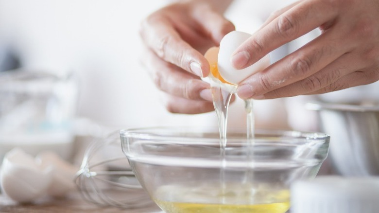 Cracking egg whites into bowl