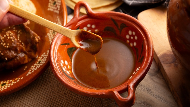 Earthenware bowl and spoonful of mole poblano