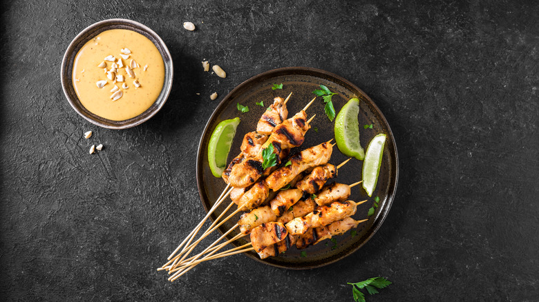 Plate of chicken satay with bowl of Thai peanut sauce