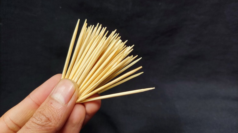 person holding toothpicks