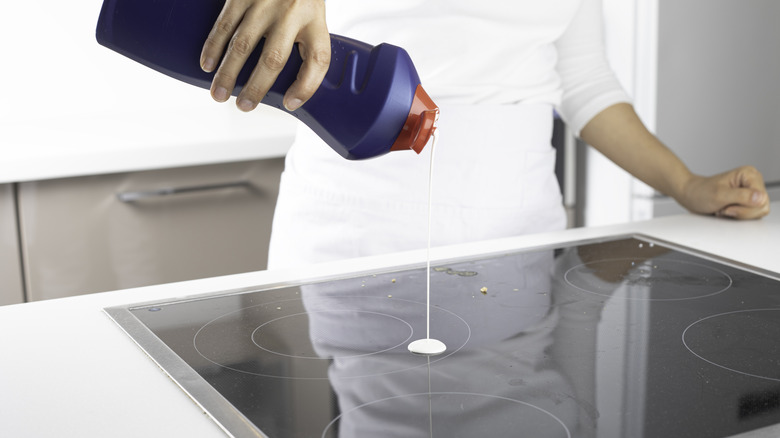 pouring cleaner onto induction stove